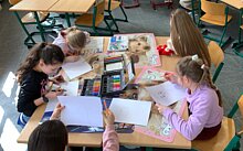 Zu sehen sind Kinder am Nachmittag beim Spiel oder beim Basteln. 