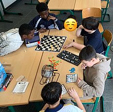 Zu sehen sind Kinder am Nachmittag beim Spiel oder beim Basteln.